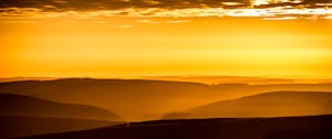 Breathtaking golden sunrise over rolling hills, capturing serene beauty and vibrant colors.